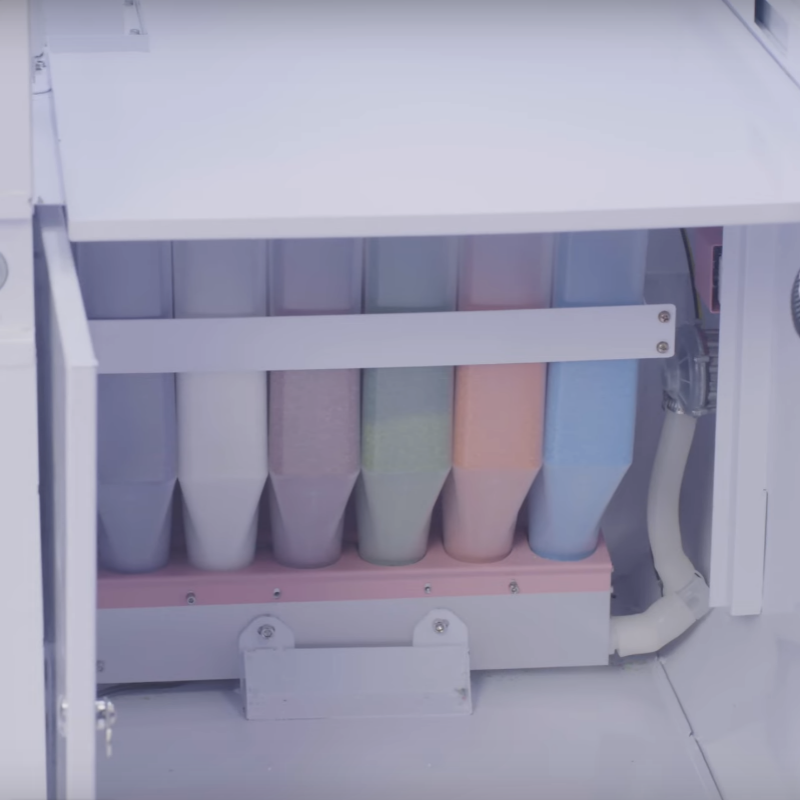 a view of the storage containers where you refill the six different colors and flavors of sugar crystals to make cotton candy in the Sweet Robo Model VX Cotton Candy Vending Machine