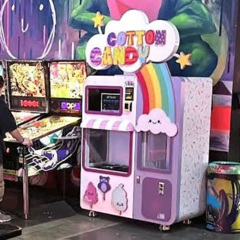 a Sweet Robo Model VX Cotton Candy Vending Machine in an arcade next to some pinball machines